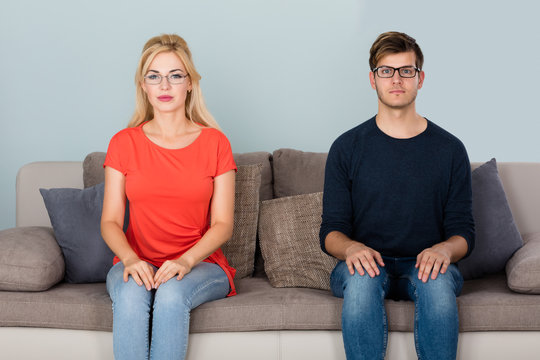 Man And Woman Wearing Eyeglasses On Couch
