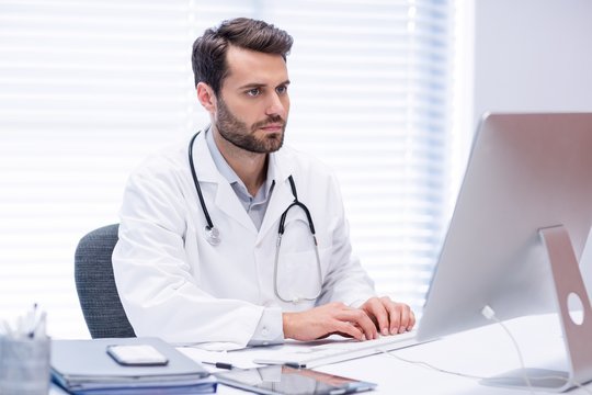Male doctor working on personal computer