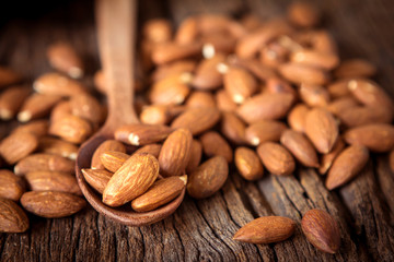 close up Peeled almonds nut in spoon on wooden  background