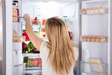 Woman Looking At Food In Refrigerator