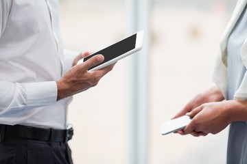 Business executives holding digital tablet and mobile phone