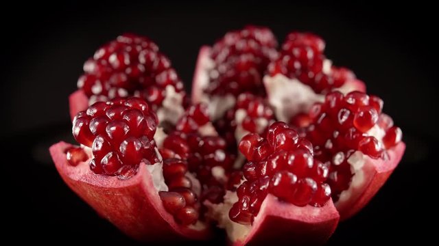 Open Pomegranate Fruit Showing Delicious Seeds Rotating Isolated by Black Background