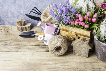 Fototapeta na wymiar Home and garden concept of gardening tools and flowers on the old wood