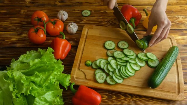 Woman hands cuttind cucunber on salad, 4k timelapse video
