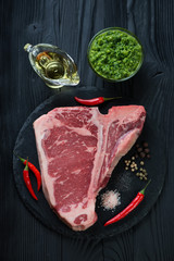 Raw fresh black angus club steak over black wooden background
