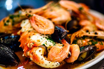 Shrimp, crayfish and mussels are on the big dish in the sauce.