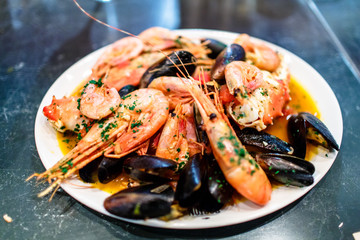 Shrimp, crayfish and mussels are on the big dish in the sauce.