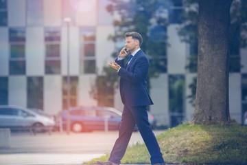 Businessman using mobile phone while walking