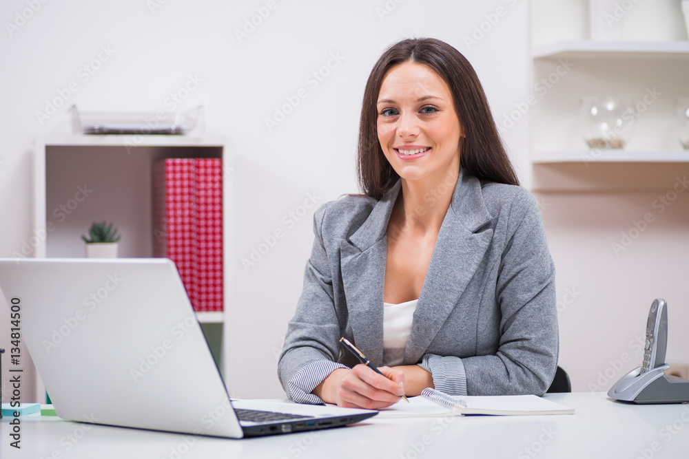 Wall mural young businesswoman is working in her office.