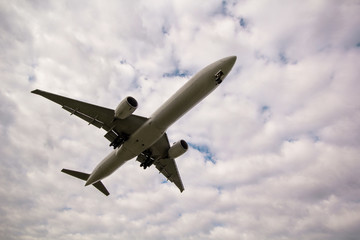 Fototapeta na wymiar Overhead airplane on landing with a beautiful sky with clouds