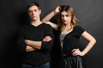 Model Girl and guy posing in stylish clothes on a black background.