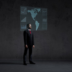 Businessman standing next to a futuristic map