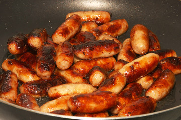 Plate of hot cooked cocktail sausages ready to eat.