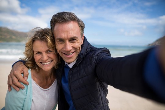 Mature couple smiling at camera on the beach