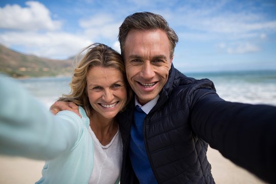Mature couple smiling at camera on the beach