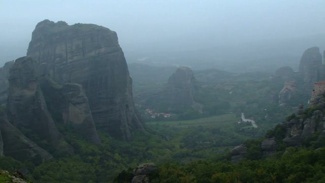 Pan across a misty view of the hills and monasteries of Meteora near Volos, Greece