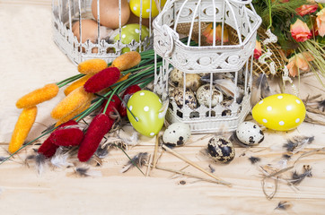 Easter still life. Bird cage with quail eggs and spring flowers