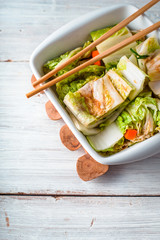 Kimchi in the ceramic bowl in the white wooden table