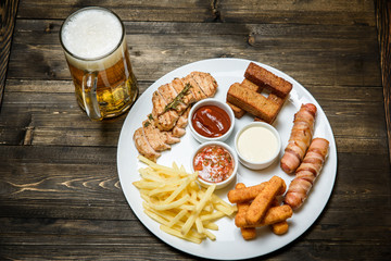 Beer in a glass on wooden background. and snack.