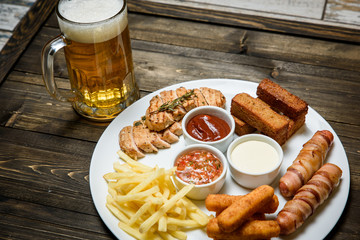 Beer in a glass on wooden background. and snack.