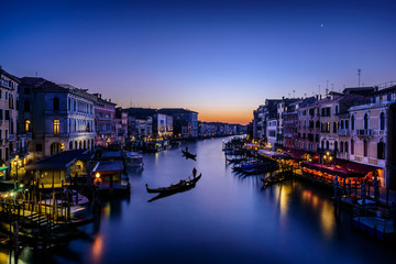 Long exposure of the Grand Canal seen from Rialto bridge at sunset. Gondolas seem resting on the...