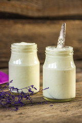Yogurt in jar on the wooden table with purple dried plant