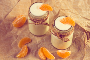 Organic yougurt with fresh tangerine in glass jars