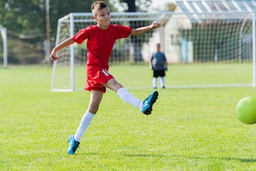 Boy kicking soccer ball
