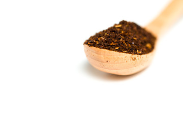 A chili flakes in a wooden spoon isolated over white background