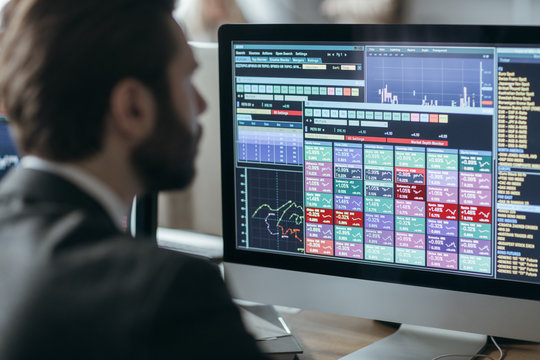 Man broker analyizing chart and stock market performance forecas