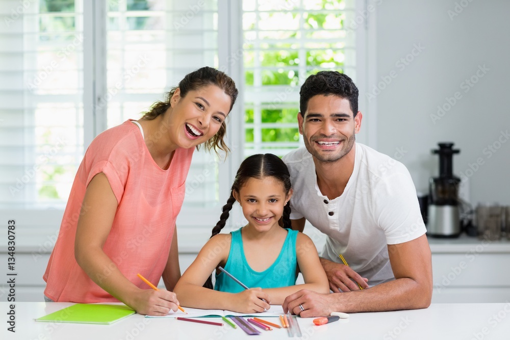 Poster Parents and daughter drawing in kitchen at home