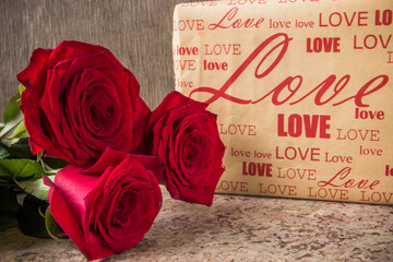 Red roses and gift covered craft paper