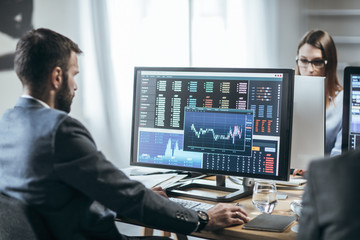 Businesspeople working with finance forecasts on their computers