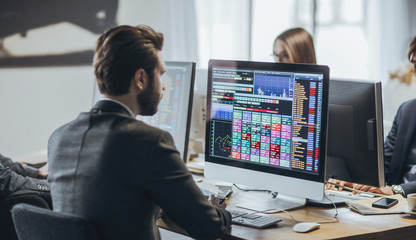 Broker analysing stock market on his computer.