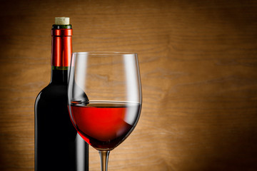 Wine glass and bottle on a wooden background