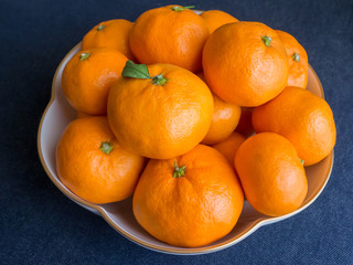 Mandarin oranges stacked in a flower shaped china bowl