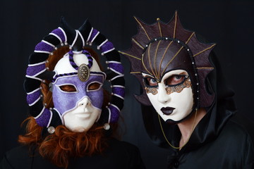 girl in red hair and a guy in an old Venetian masks