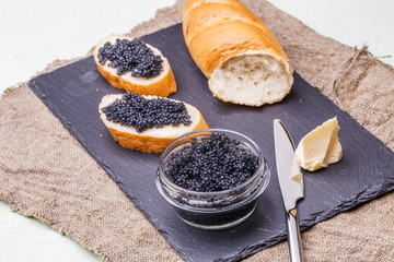 Photography of black caviar, knife