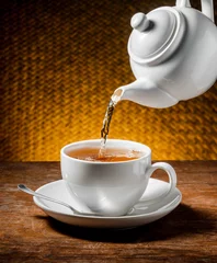 Fotobehang Thee Tea being poured into tea cup