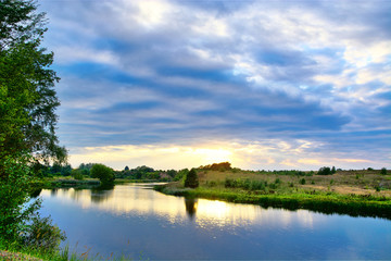 Fototapeta na wymiar Autumn landscape of blue cloudy sunrise by the river