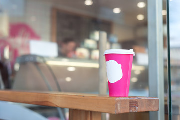 pink coffee cup in coffee shop. copy space for logo