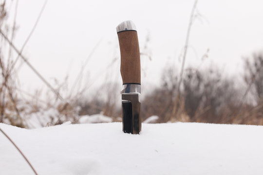 sharp hunting knife, stuck in the snow
