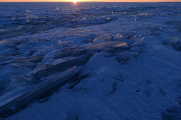Winter ice desert of broken ice in the sunset light