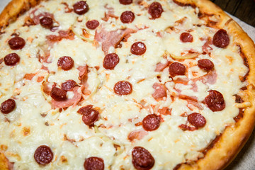 Top view of Italian rustic PIZZA on wooden table background