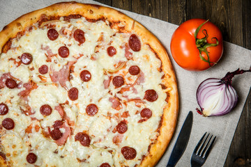Top view of Italian rustic PIZZA on wooden table background
