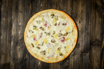 Top view of Italian rustic PIZZA on wooden table background