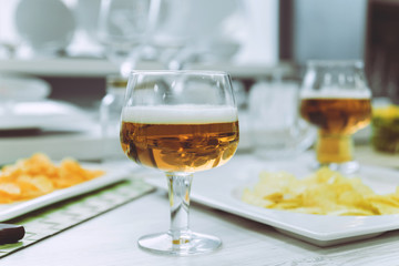 Beer and chips on the large white table