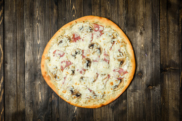 Top view of Italian rustic PIZZA on wooden table background