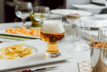 Beer and chips on the large white table