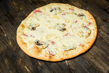 Top view of Italian rustic PIZZA on wooden table background